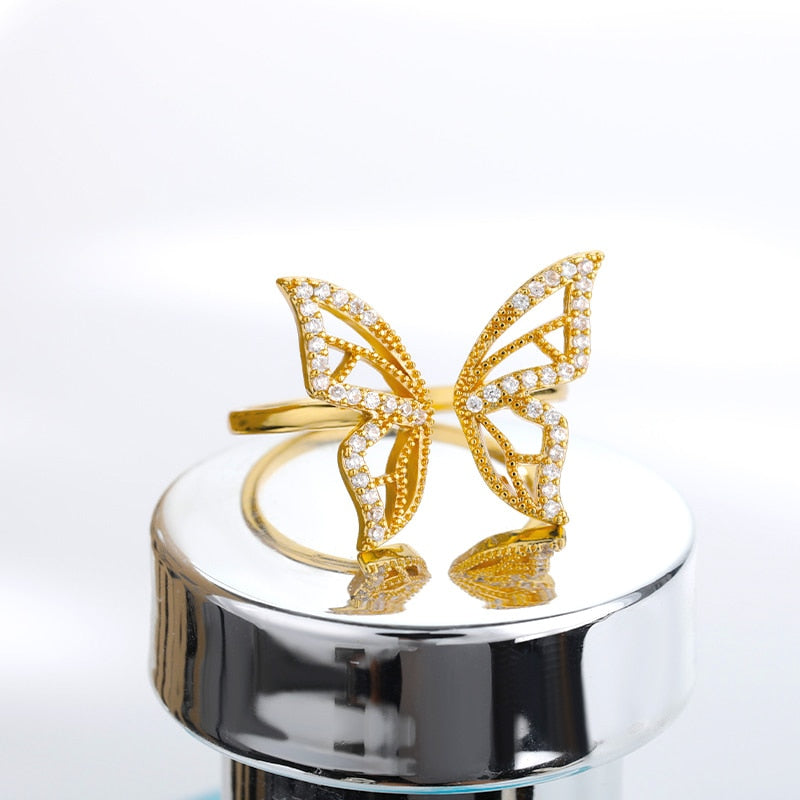 gold butterfly ring on pedestal